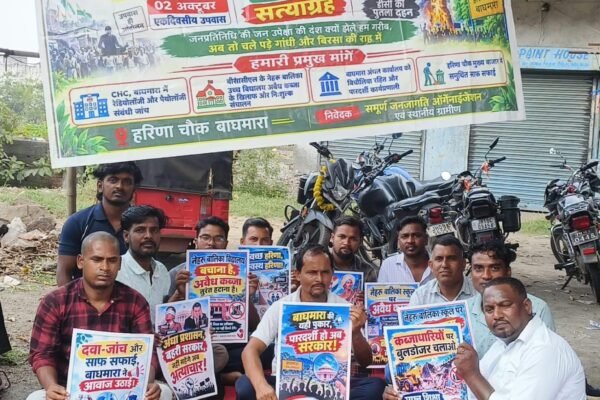 Dhanbad News: बाघमारा CHC में रेडियोलॉजी-पैथोलॉजी सेवा शुरू करने की मांग को लेकर ग्रामीणों ने हरिणा चौक पर किया सत्याग्रह